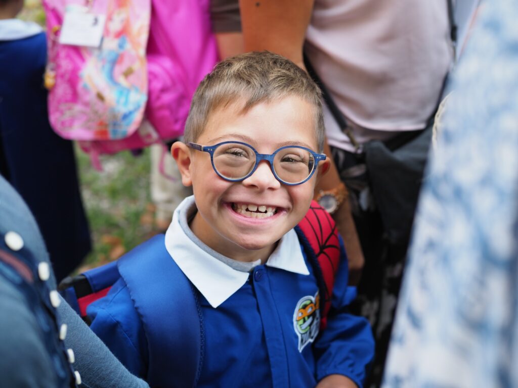Bambino sorridente che indossa un grembiule da scuola