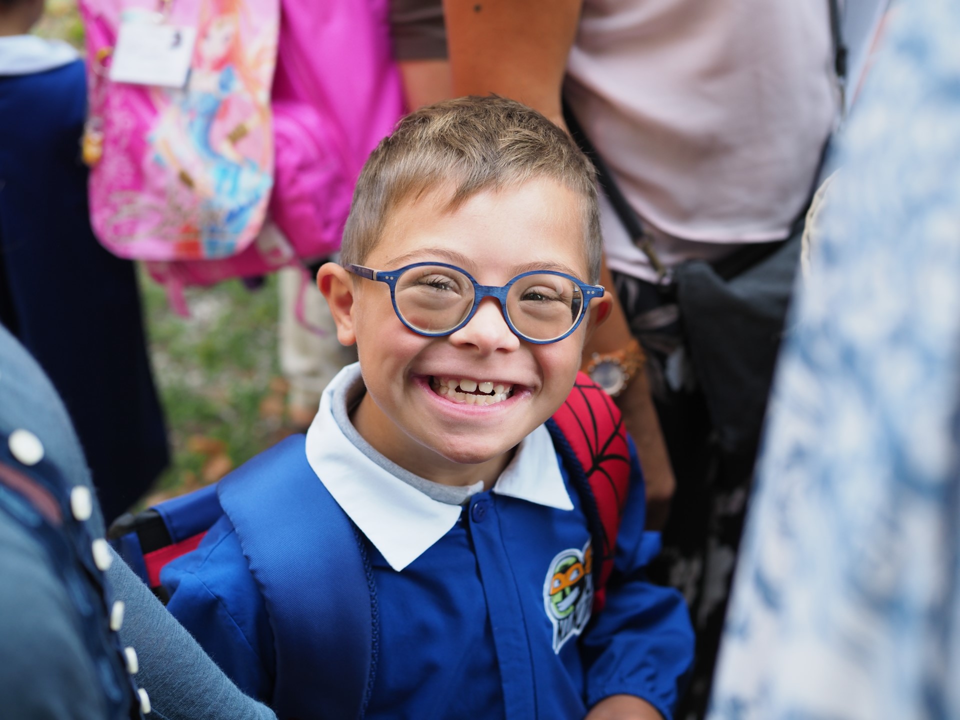Bambino sorridente che indossa un grembiule da scuola
