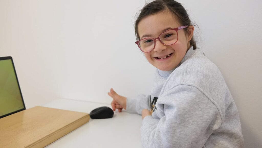 bambina sorridente studia al computer