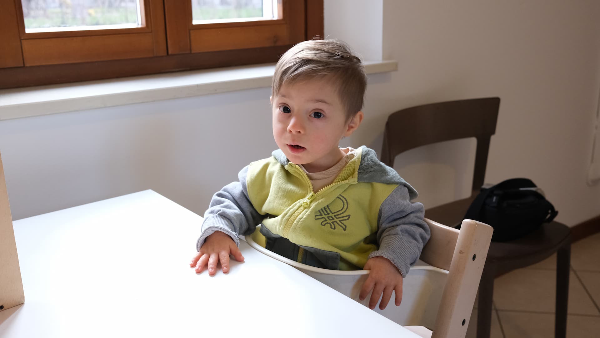 Bambino di due anni seduto su un seggiolone