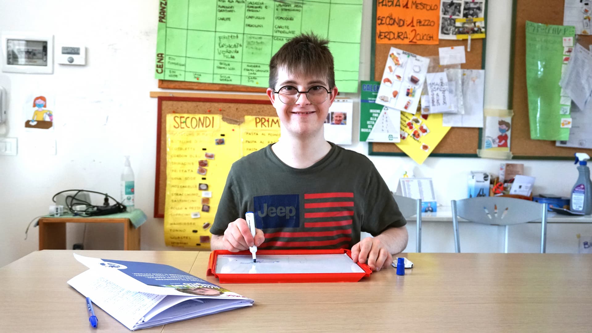 Ragazzo sorridente scrive di una lavagna