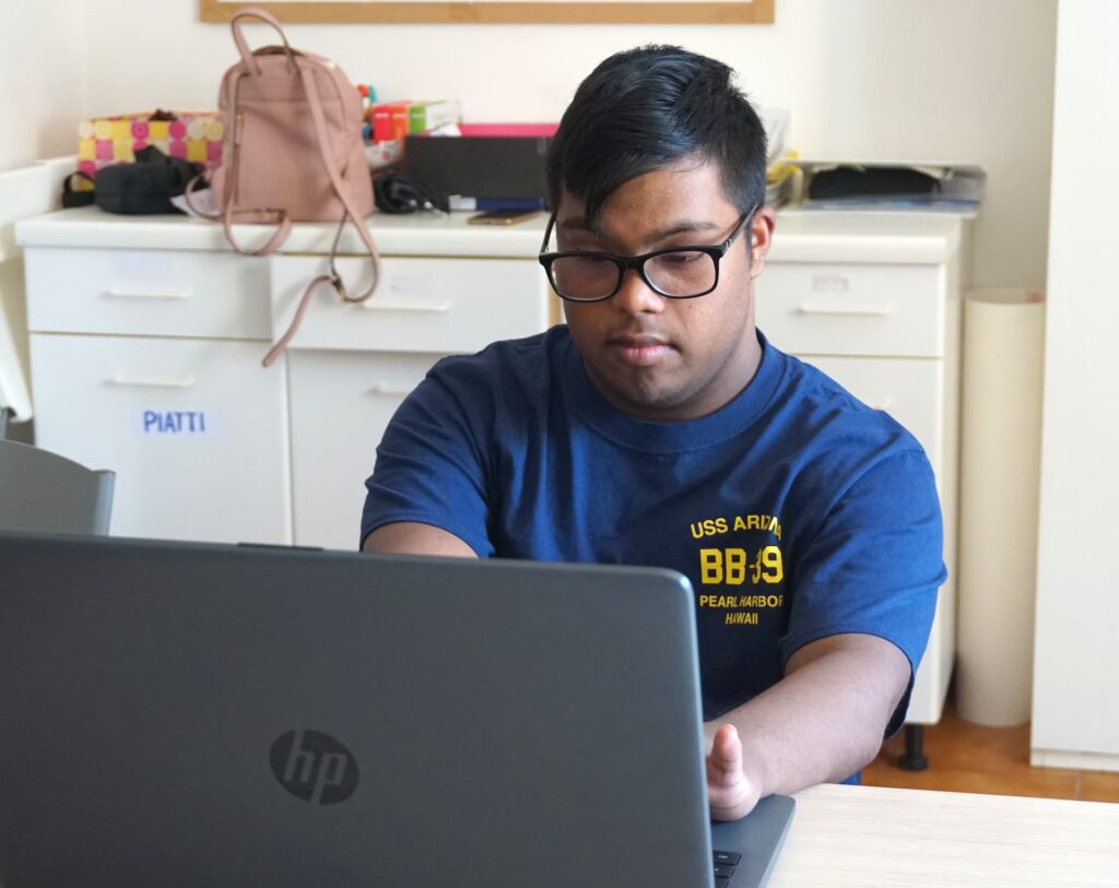 ragazzo con gli occhiali studia al computer