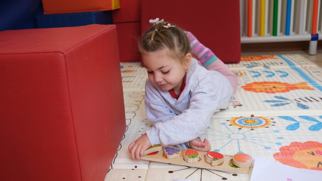 Bambina gioca con giocattoli a forma di frutta