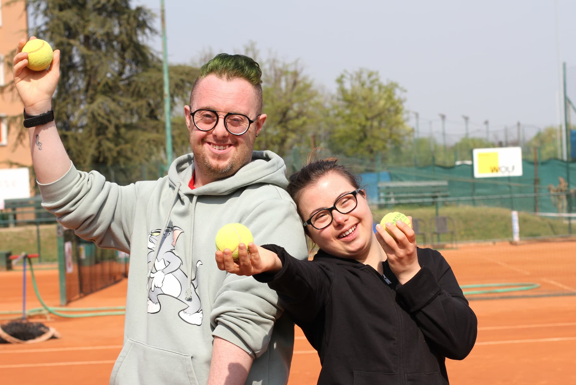 Persone sorridenti che fanno attività sportiva su un campo da tennis