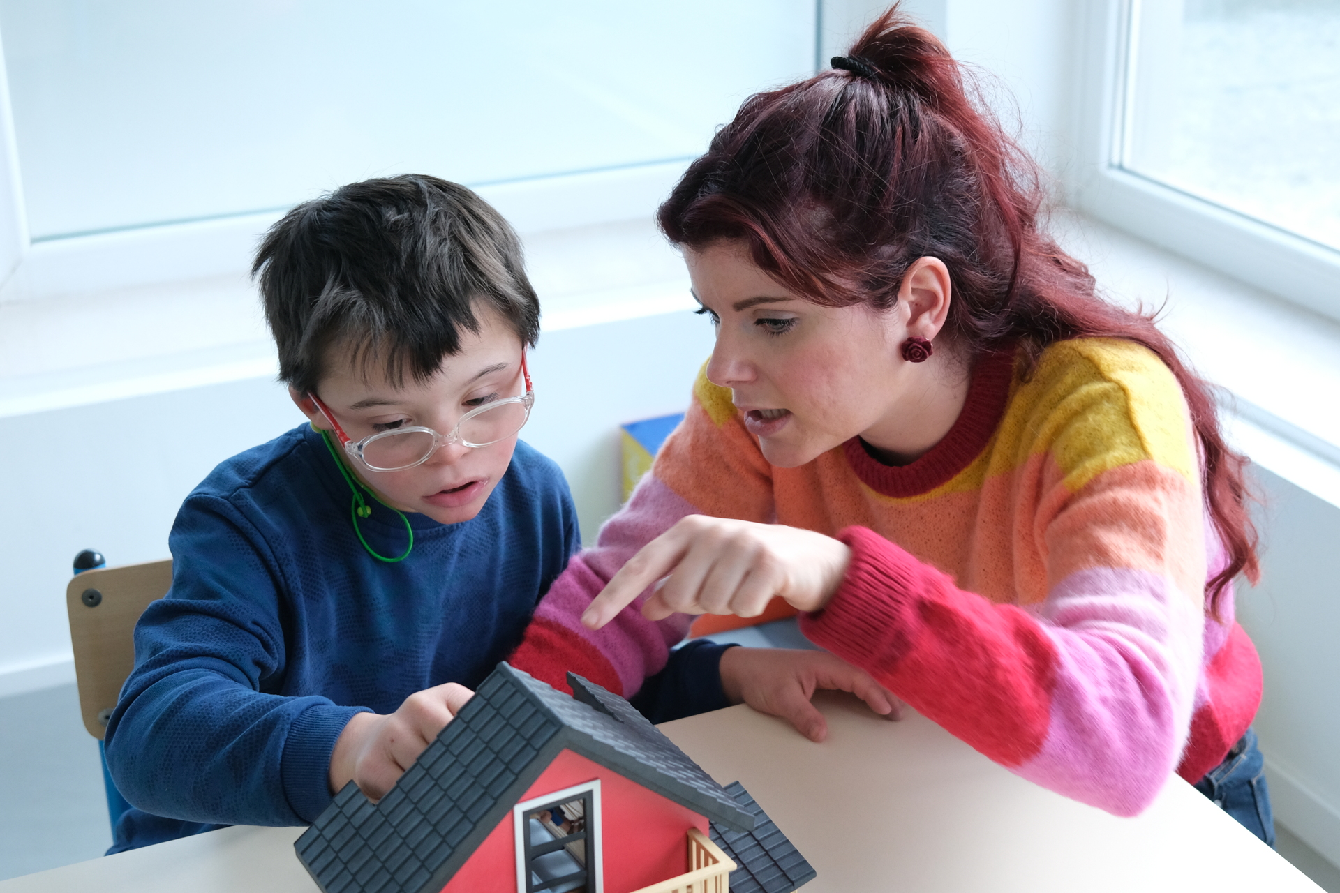 tutor gioca con un bambino affetto da sindrome di down