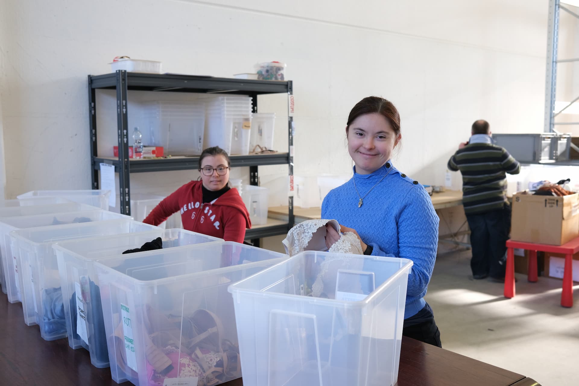 Ragazze svolgono attività di volontariato organizzando capi d'abbigliamento